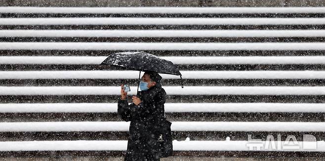 [서울=뉴시스] 홍효식 기자 = 서울과 수도권에 폭설이 내린 27일 오후 서울 중구 남산골한옥마을을 찾은 관광객들이 내리는 눈을 스마트폰으로 촬영하고 있다. 2024.11.27. yesphoto@newsis.com