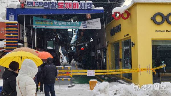 수도권에 큰 눈이 내린 28일 오전 의왕 도깨비시장 천장이 눈으로 붕괴돼 관계자들이 눈을 치우고 있다. 윤원규기자