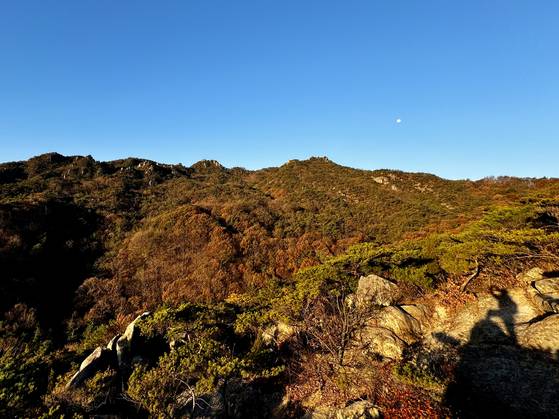 용봉산 병풍바위로 향하는 능선 상의 한 바위에서 사진을 찍는 탐방객. 김홍준 기자