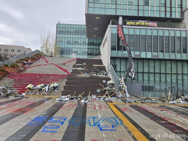 27일 백주년 기념관 앞 계단에 빨간 래커로 물들어 있다. 바닥엔 '공학 반대' 등의 래커로 쓴 글씨가 가득하다/사진=이혜수 기자
