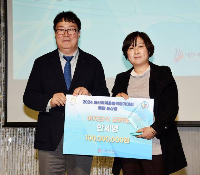 김택규 대한배드민턴협회 회장이 지난달 30일 경남 밀양 아리나호텔에서 열린 2024 파리올림픽 포상식에서 길영아 삼성생명 감독에게 1억 원의 포상금을 전달하고 있다. 길 감독은 이날 제자 안세영을 대신해 행사에 참가했다. 밀양=뉴시스