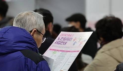 노인 일자리 사업 안내문을 읽고 있는 어르신. 연합뉴스