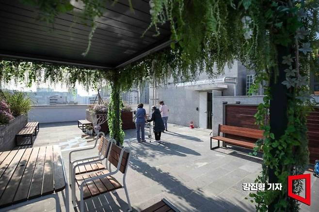 24일 서울 은평구 시립은평실버케어센터 옥상정원에서 어르신이 요양보호사와 함께 산책하고 있다. 시립은평실버케어센터는 서울시가 전국 최초로 민간 개발사업 공공기여 방식으로 노인 전용 돌봄 시설을 기부채납 받아 수색13구역 주택 재개발 사업지에 건립한 곳이다. 지하 1층부터 지상 6층 규모의 공공 노인요양시설로 지난 5월 문을 열었다. 사진=강진형 기자