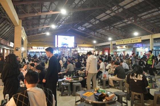 충남 예산군 예산시장이 재개장한 첫날인 지난해 4월1일 시장에서 산 음식을 먹을 수 있는 마당에 관광객이 붐비고 있다. 예산군