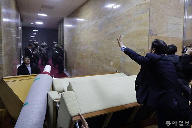 한 국회 직원이 대치중인 계엄군에게 “방금 본회의에서 계엄 해제요구 결의안이 가결됐다”라며 “당신들 거기서 한 발짝이라도 움직이면 모두 위법행위를 저지른 것”이라고 소리치고 있다. 박형기 기자 oneshot@donga.com