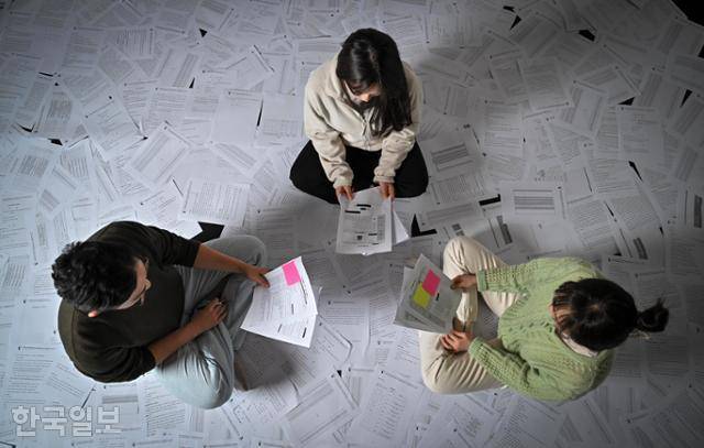 한국일보 특별취재팀은 딥페이크 범행을 저지른 10대 면면을 살펴보기 위해 관련 학교폭력 조치결정 통보서 40건과 미성년 가해자에 대한 기록이 담긴 판결문 등을 분석했다. 본보가 입수한 통보서와 판결문 수백장을 펼쳐놓고 특별취재팀 기자들이 가해자의 특징을 살펴보고 있다. 정다빈 기자