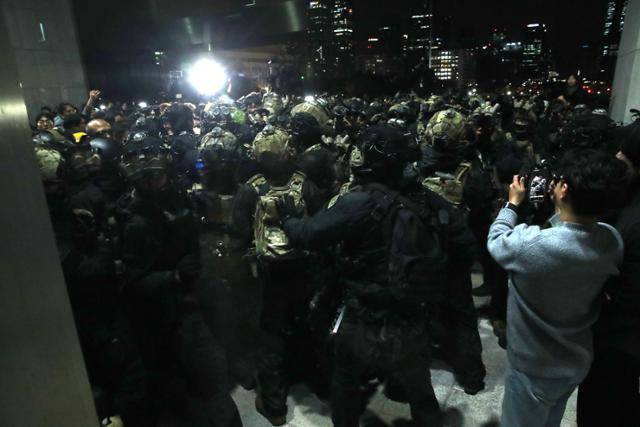 윤석열 대통령이 3일 밤 비상계엄을 선포한 가운데 4일 새벽 서울 여의도 국회 본청 앞에서 경내로 진입하려는 계엄군과 국회 관계자들이 몸싸움을 벌이고 있다. 뉴스1