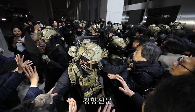 윤석열 대통령이 비상계엄을 선포한 후 자정을 넘긴 4일 새벽 서울 여의도 국회의사당에 도착한 무장군인들이 국회본청 진입을 시도하자 국회 직원 등이 격렬히 막아서고 있다. 2024.12.4 /성동훈 기자