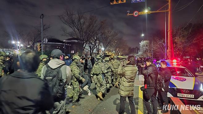 4일 국회 앞에 모인 시민들이 계엄령 해제에 나오는 군인들을 향해 박수와 격려의 말을 건네고 있다. 사진=임현범 기자