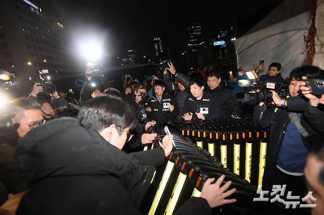 윤석열 대통령이 비상계엄을 선포한 3일 밤 서울 여의도 국회 출입문에서 국회 관계자와 경찰이 대치하고 있다. 박종민 기자