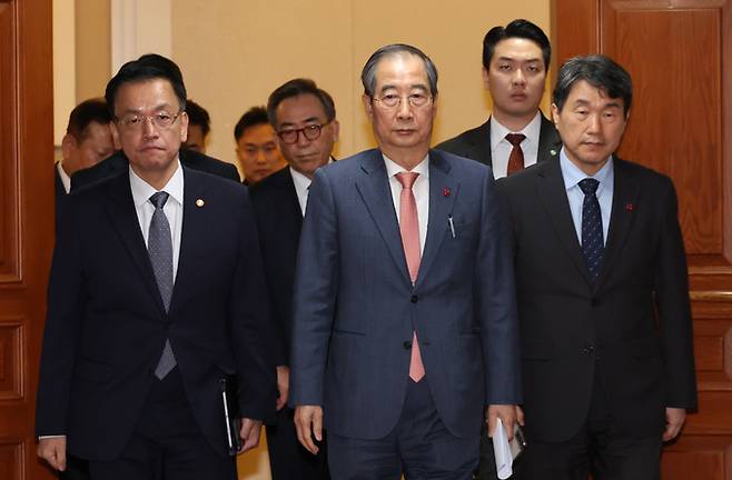 한덕수 국무총리가 4일 오전 서울 종로구 정부서울청사에서 윤석열 대통령이 긴급 담화로 비상계엄 해제를 선언 가운데 긴급 소집된 회의를 마친후 최상목 경제부총리 겸 기획재정부 장관, 이주호 사회부총리 겸 교육부 장관 및 국무위원들과 국무회의실을 나서고 있다.&nbsp; &nbsp;뉴시스
