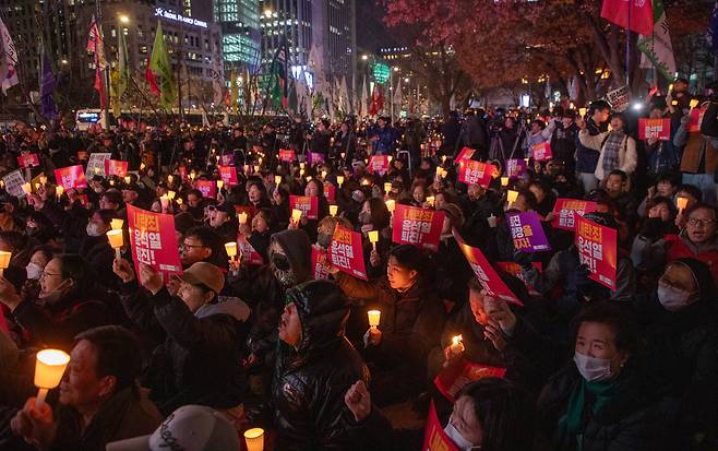 4일 오후 서울 동화면세점 앞에서 열린 '내란죄 윤석열 퇴진! 시민촛불' 집회에서 전국민주노동조합총연맹을 비롯한 참석자들이 촛불과 피켓을 들고 있다. /박상훈 기자