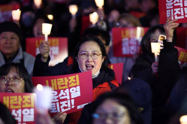 4일 서울 광화문 동화면세점 앞에서 전국민주노동조합총연맹 주최로 열린 ‘내란죄 윤석열 퇴진! 시민촛불’에서 참가자들이 촛불을 들고 있다. 연합뉴스