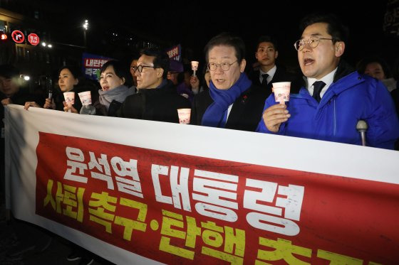 이재명 더불어민주당 대표와 박찬대 원내대표, 김민석 최고위원이 4일 오후 서울 여의도 국회 본청 앞 계단에서 열린 윤석열 대통령 사퇴촉구ㆍ탄핵 추진 범국민 촛불문화제에서 참가자들과 함께 국회 경내를 행진하고 있다. 뉴스1