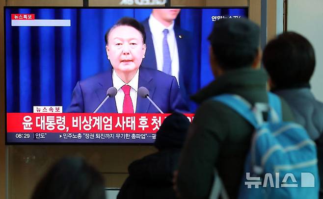 [서울=뉴시스] 김혜진 기자 = 윤석열 대통령이 비상계엄 해제를 선언한 4일 오전 서울역 대합실에서 시민들이 관련 뉴스를 보고 있다. 2024.12.04. jini@newsis.com