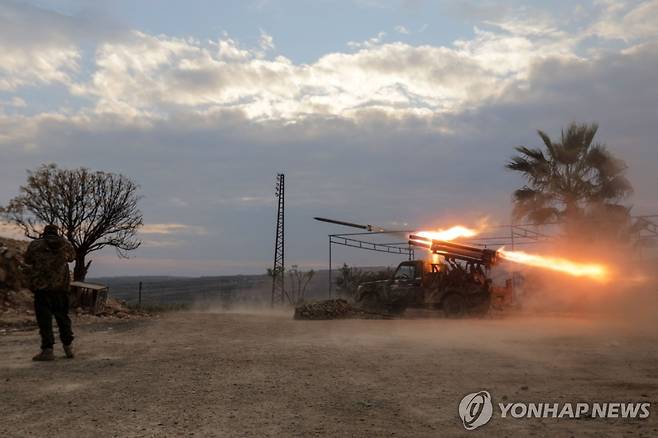 시리아 반군 (AFP 연합뉴스) 4일(현지시간) 시리아 반군이 중부 거점도시 하마의 북쪽 외곽 지역에서 정부군 주둔지를 향해 다연장 로켓을 발사하고 있다. 2024.12.5 dk@yna.co.kr