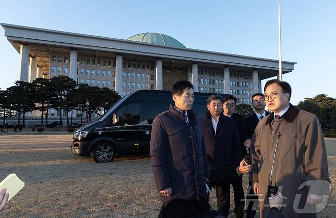 우원식 국회의장과 김민기 국회사무총장이 6일 오후 서울 여의도 국회 잔디밭에 2차 계엄 우려로 헬기 등을 착륙하지 못하게 버스와 차량으로 막은 현장을 살펴보고 있다. 2024.12.6/뉴스1 ⓒ News1 이재명 기자