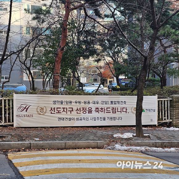 평촌 선도지구로 선정된 샘마을 아파트 단지 앞에 건설사들이 내건 축하 현수막이 걸려 있다.  2024.12.5 [사진=이효정 기자 ]
