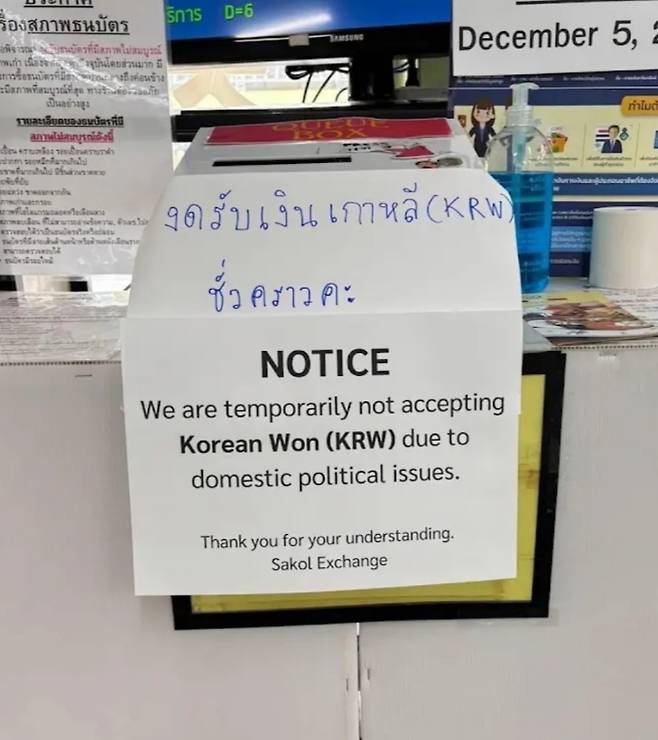 지난 4일 밤 한 온라인 커뮤니티에 올라온 사진. 태국 일부 환전소에서 찍은 것으로 추정되는 사진으로, ‘한국 내 정치적인 문제로 인해 우리는 일시적으로 원화를 받지 않는다’라는 내용이 게재돼 있다. (온라인 커뮤니티 캡처)