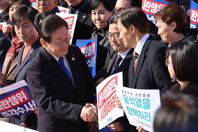 더불어민주당 이재명 대표와 조국혁신당 조국 대표가 지난 4일 열린 ‘윤석열 대통령 사퇴촉구 탄핵추진 비상시국대회’에서 만나 악수하고 있다. [연합]