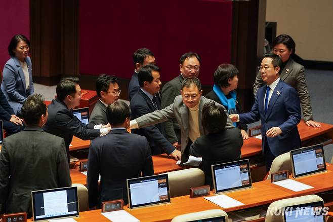 7일 국회 본회의장에서 국민의힘 의원들이 윤석열 대통령 탄핵소추안 표결에 반대하며 집단 퇴장한 가운데 김상욱 국민의힘 의원이 본회의장으로 돌아오자 더불어민주당 의원들이 반갑게 맞이하고 있다. 사진=유희태 기자