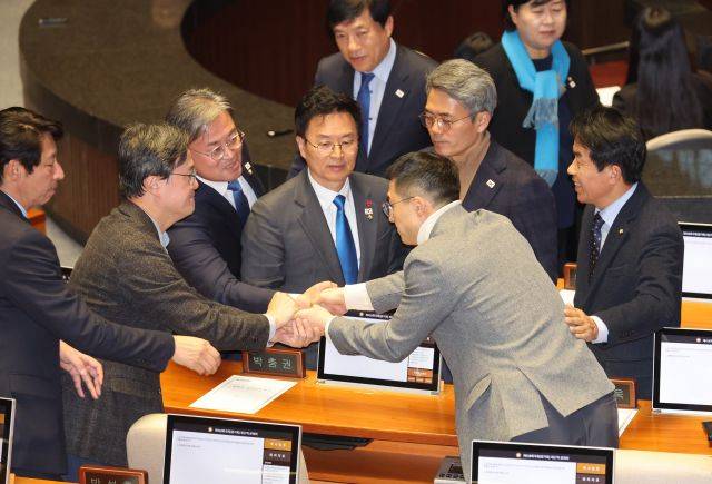 김상욱 국민의힘 의원(오른쪽)이 7일 오후 국회 본회의에서 윤석열 대통령의 탄핵소추안에 대해 투표한 뒤 야당 의원들과 인사하고 있다. 연합뉴스