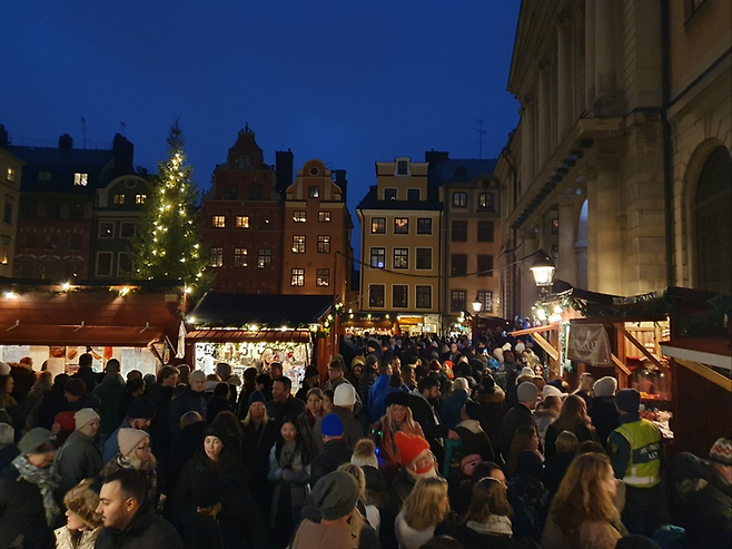 한강 작가의 노벨 강연이 열린 스웨덴 한림원(오른쪽 건물) 앞 광장에 행인들이 운집한 모습.  감라스탄(Gamla stan·구시가지를 뜻하는 스웨덴어)에 위치한 명소로 스톡홀름의 인기 관광지다. [김유태 기자]