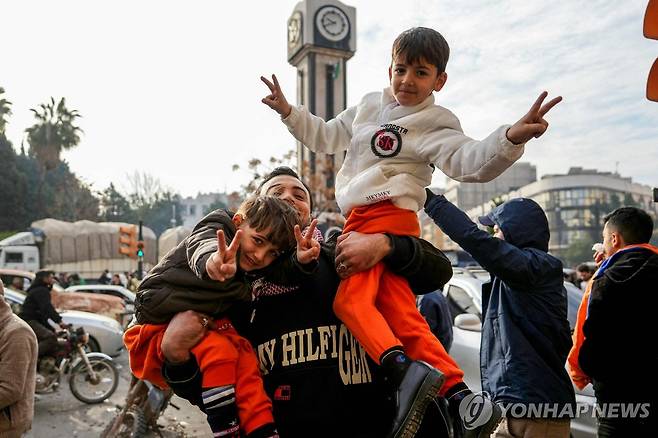 기뻐하는 시리아 시민들 (홈스 AFP=연합뉴스) 8일(현지시간) 시리아 홈스의 광장에서 아사드 정권 몰락에 기념하는 시민들. 2024.12.08S