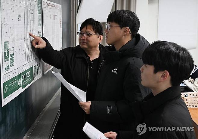 2025학년도 대학수학능력시험(수능) 성적표가 배부된 6일 서울 종로구 동성고등학교에서 고3 담임 선생님이 수험생들과 지원 가능 대학 배치표를 살펴보고 있다.ⓒ연합뉴스