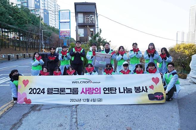 지난 6일 연탄 나눔 봉사에 참여한 웰크론그룹 임직원들이 기념 사진을 촬영하고 있다. <사진 제공=웰크론그룹>