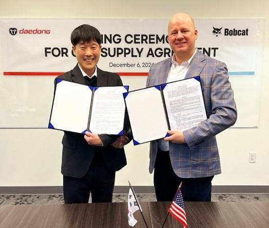 지난 12월 6일(북미 현지) 두산밥캣 북미법인에서 계약 체결 후 한인기 대동 신사업본부장(왼쪽)과 트람파스 굿맨슨(Trampas Goodmanson) 두산밥캣 북미법인 부사장이 기념 사진을 촬영하고 있다. [사진제공=대동]