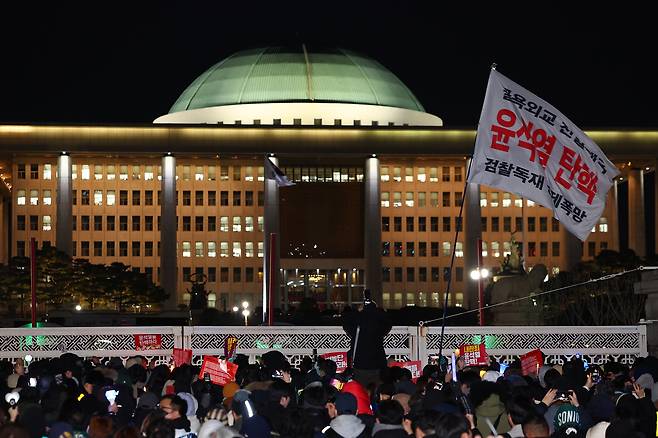 윤석열 대통령에 대한 탄핵소추안이 국회 본회의에서 의결 정족수 미달로 폐기된 7일 오후 시민들이 서울 여의도 국민의힘 당사 앞에서 집회를 이어가고 있다. [연합]