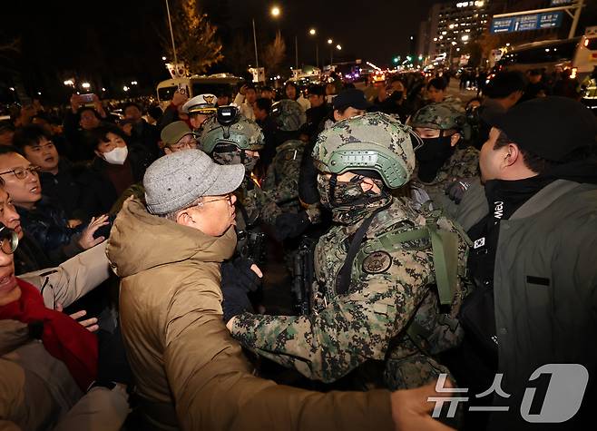 윤석열 대통령이 비상계엄령을 선포한 가운데 4일 새벽 서울 여의도 국회 앞에 모인 시민들이 계엄군 진입을 막아서고 있다. 2024.12.4/뉴스1 ⓒ News1 구윤성 기자