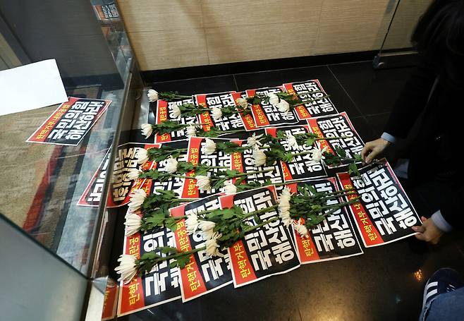 윤석열정권퇴진·한국사회대전환 제주행동이 지난 9일 제주시 연동 국민의힘 제주도당 앞에서 기자회견을 한 뒤 닫힌 문 앞에 ‘탄핵 거부 내란 공범 국민의힘 해체하라’는 손팻말과 국화꽃을 놓았다. 연합뉴스