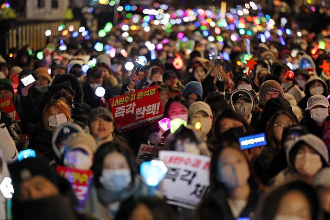 12월8일 오후 서울 여의도 국회 앞에서 열린 윤석열 탄핵 및 구속을 촉구하는 촛불문화제에서 참가자들이 관련 손팻말과 응원봉을 들고 있다. ⓒ연합뉴스