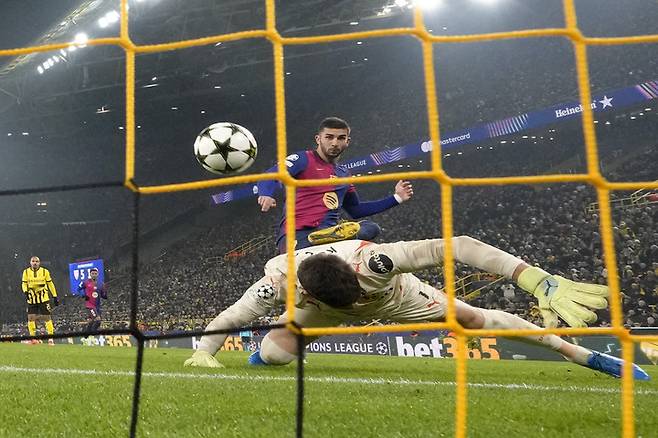 2024년 12월 11일 수요일, 독일 도르트문트의 지그날 이두나 파크에서 열린 보루시아 도르트문트와 FC 바르셀로나의 챔피언스리그 조별 예선 축구 경기 중 바르셀로나의 페란 토레스가 도르트문트 골키퍼 그레고어 코벨을 상대로 팀의 두 번째 골을 넣고 있다. (AP 사진/마틴 마이스너)