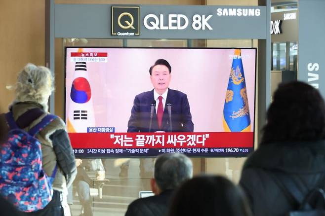 12일 오전 서울역에서 시민들이 윤석열 대통령 담화를 TV로 보고 있다. 연합뉴스