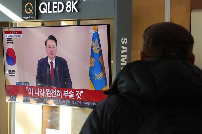 내란죄 피의자 윤석열 대통령이 긴급담화를 한 12일 오전 서울 중구 서울역 대합실에서 시민들이 텔레비전으로 담화를 시청하고 있다. 김영원 기자 forever@hani.co.kr