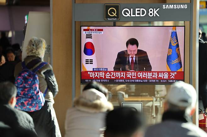 내란죄 피의자 윤석열 대통령이 긴급담화를 한 12일 오전 서울 중구 서울역 대합실에서 시민들이 텔레비전으로 담화를 시청하고 있다. 김영원 기자 forever@hani.co.kr