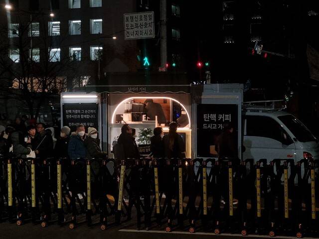 시민들이 12일 저녁 6시 서울 영등포구 국회의사당역 5번 출구 앞에서 열린 ‘내란수괴 윤석열 즉각 탄핵! 시민촛불’ 집회 현장에 차려진 ‘탄핵 커피차’ 앞에 줄을 서 있다. 고나린 기자