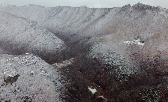 전망대에서 드론을 띄워 바라본 내장산 산세. 설경 속에서 끝물 단풍이 잔잔한 홍조를 띤다. 사진 오른쪽에 벽련암, 왼쪽에는 전망대, 가운데에 내장사가 자리한다.