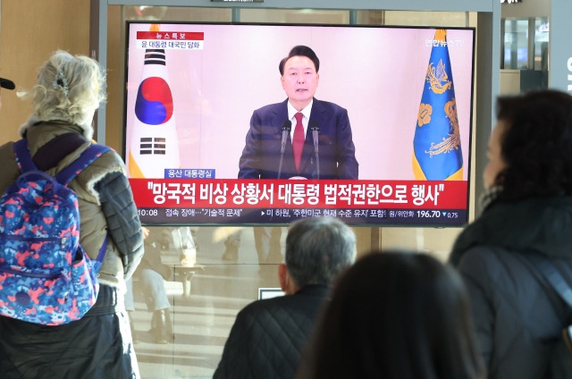 12일 오전 서울역에서 시민들이 윤석열 대통령 담화를 TV로 보고 있다. 연합뉴스