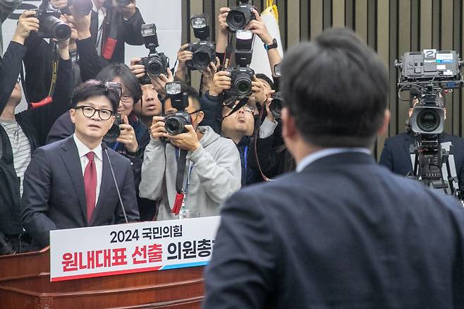 국민의힘 한동훈 대표가 12일 국회에서 열린 당 의원총회에서 발언을 하던 중 강명구(뒷모습) 의원이 일어나 항의하고 있다. 한 대표가 윤석열 대통령의 이날 대국민 담화에 대해 “사실상 내란을 자백하는 취지”라고 하자, 강 의원 등 친윤계 의원들은 반발했다. /장련성 기자