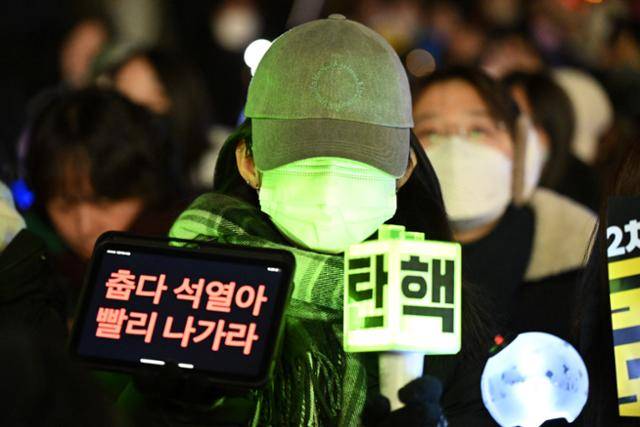 11일 서울 여의도 국회 앞에서 윤석열 대통령 탄핵 촉구 촛불집회가 열린 가운데 한 시민이 K팝 응원봉을 들고 윤 대통령의 탄핵을 촉구하고 있다. 박시몬 기자