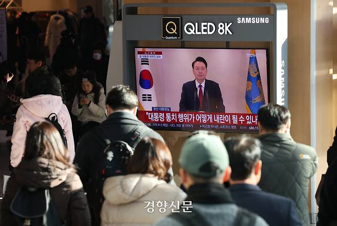 지난 12일 서울 용산구 서울역에서 시민들이 윤석열 대통령의 긴급 성명 발표를 지켜보고 있다. 권도현 기자