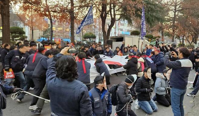 민주노총 경남본부가 국민의힘 경남도당 당사 앞에서 파업대회를 열고 윤 대통령 탄핵 표결에 불참한 국민의힘에 대한 항의를 나타내는 퍼포먼스를 하고 있다. 이세령 기자