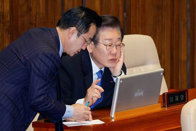 더불어민주당 이재명 대표(오른쪽)가 13일 국회 본회의장에서 박성준 원내수석부대표와 대화를 나누고 있다. 이 대표는 윤석열 대통령 2차 탄핵소추안 표결을 하루 앞둔 이날 성명을 통해 “시민들이 낮에는 일하고 밤에는 탄핵을 외치는 소위 ‘주경야탄(晝耕夜彈)’을 반복하고 있다”며 “12월 14일 우리는 ‘국민이 나라의 주인임’을 다시 선포할 것”이라고 했다. 뉴스1