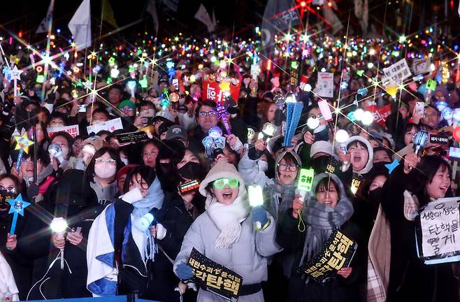 윤석열 대통령 탄핵소추안이 가결된 2024년 12월14일 서울 여의도 국회 앞에서 열린 촛불집회에 참석한 시민들이 환호하고 있다. 연합뉴스