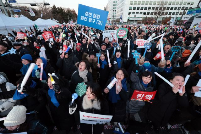 윤석열 대통령 탄핵소추안이 가결된 14일 서울 여의도 국회 앞에서 열린 촛불집회에 참석한 시민들이 탄핵이 가결되자 환호하고 있다. 연합뉴스