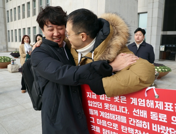 김상욱 국민의힘 의원이 13일 오전 서울 여의도 국회 본청 앞에서 윤석열 대통령 탄핵 표결 찬성을 호소하던 중 이준석 개혁신당 의원과 포옹하고 있다. 2024.12.13/뉴스1